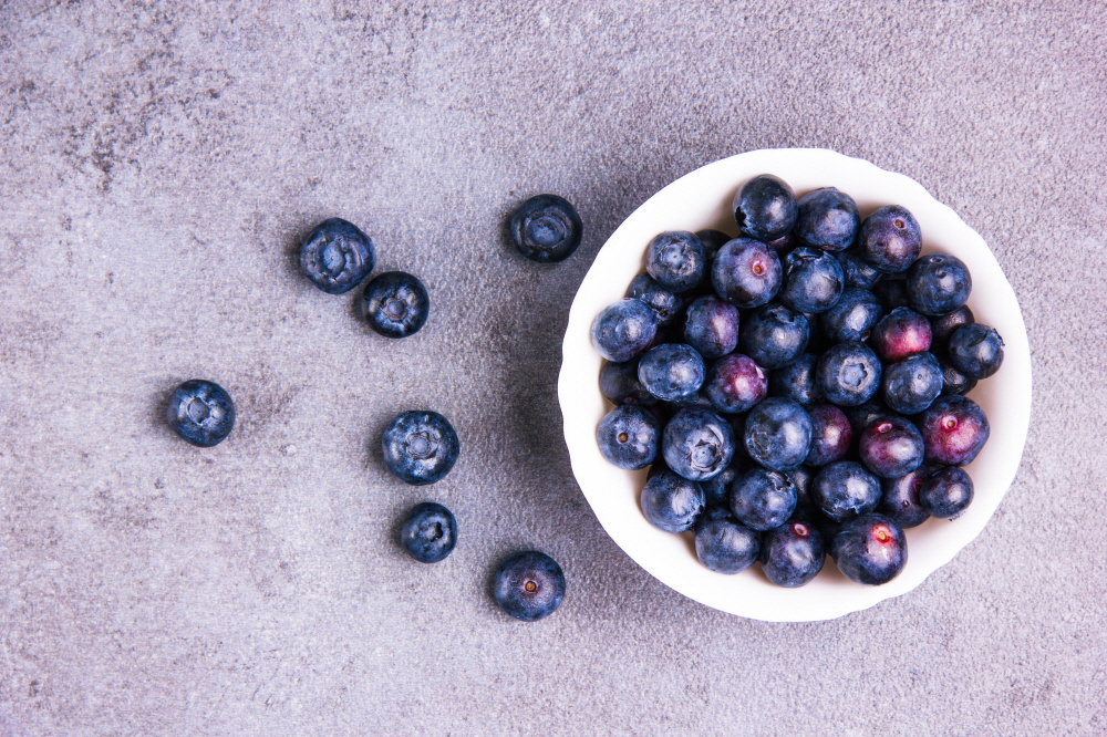 크기변환delightful blueberries white round bowl violet plaster background flat lay
